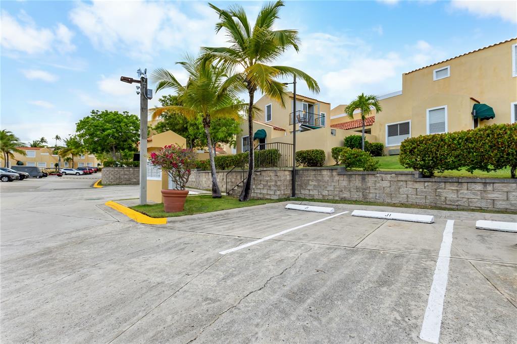 An outdoor parking area with marked spaces sits in front of a multi-story residential building — 215 HARBOUR DRIVE UNIT J1, HUMACAO, PR