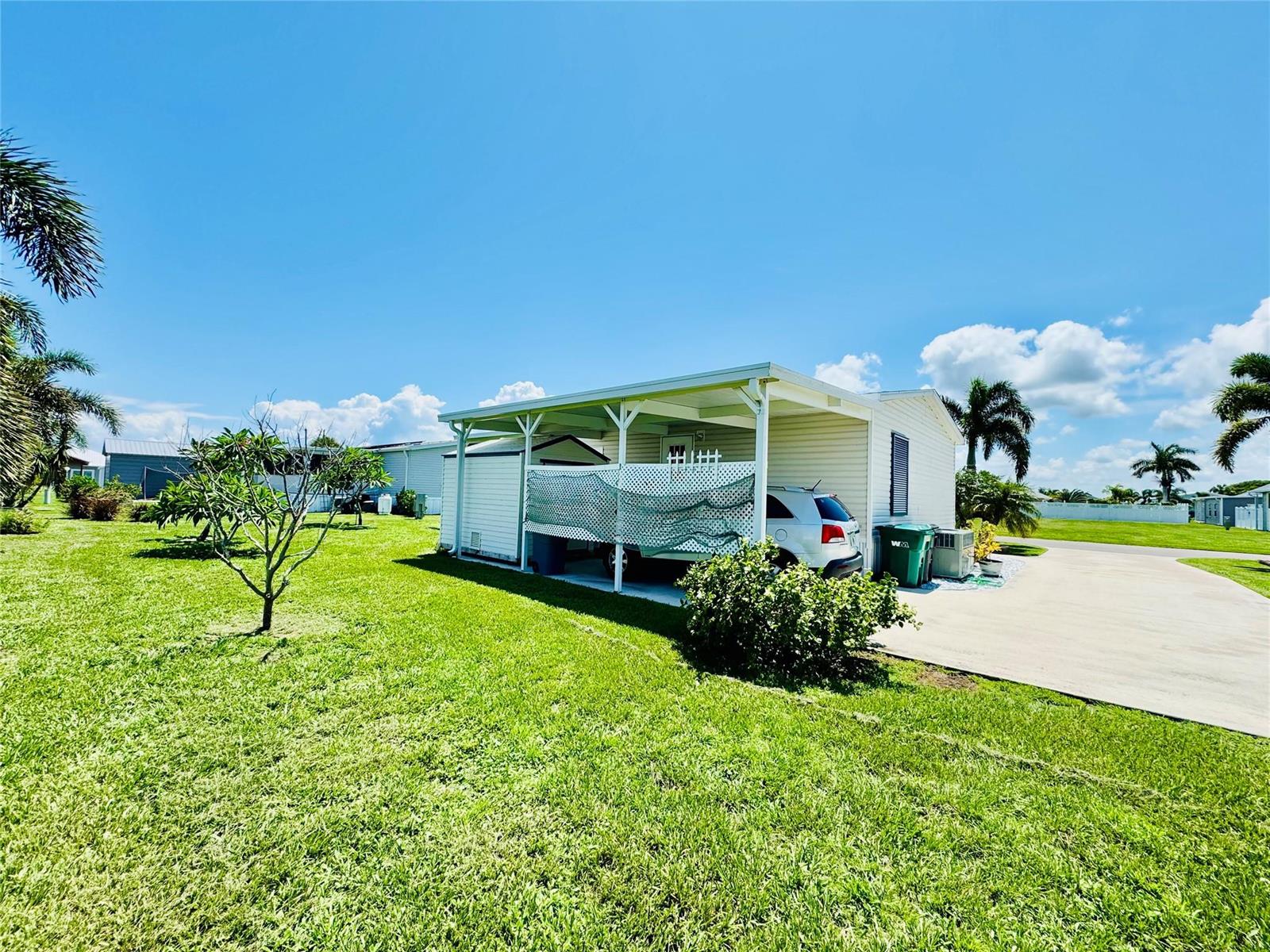A single-story mobile home with a carport and a white lattice privacy screen — 4350 SW 10th Avenue, Okeechobee FL 34974, OKEECHOBEE, FL