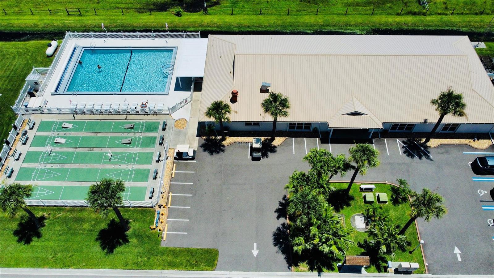 An aerial view shows a building with a pool, shuffleboard courts, and a parking lot — 4350 SW 10th Avenue, Okeechobee FL 34974, OKEECHOBEE, FL