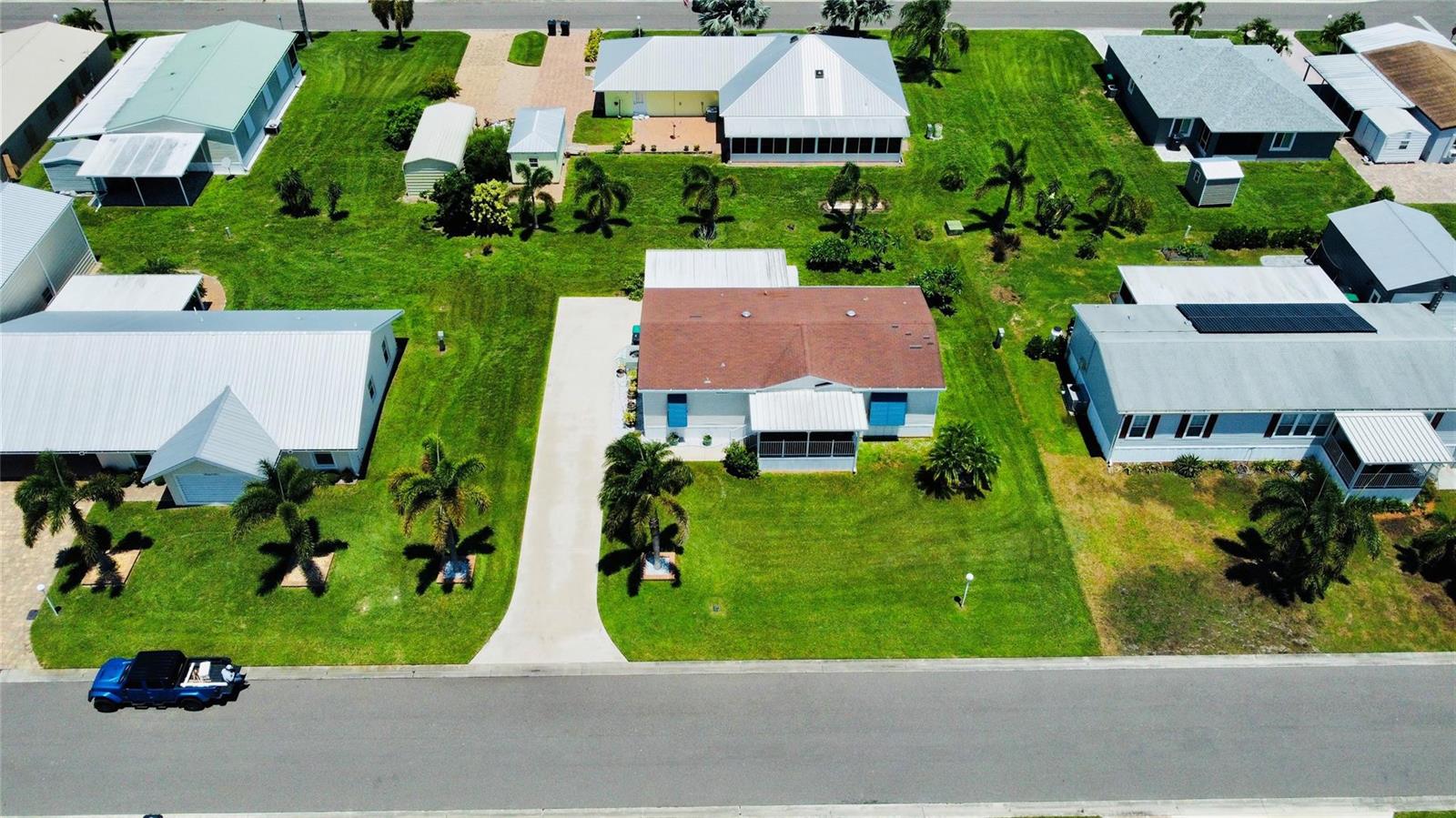 An aerial view shows a residential street with several houses, green lawns, and a blue truck — 4350 SW 10th Avenue, Okeechobee FL 34974, OKEECHOBEE, FL