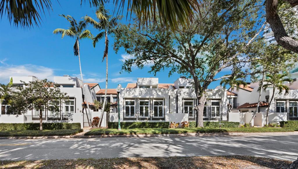 A row of white townhouses with tiled roofs and palm trees along a paved street — 200 COCOANUT AVENUE UNIT 7, SARASOTA, FL