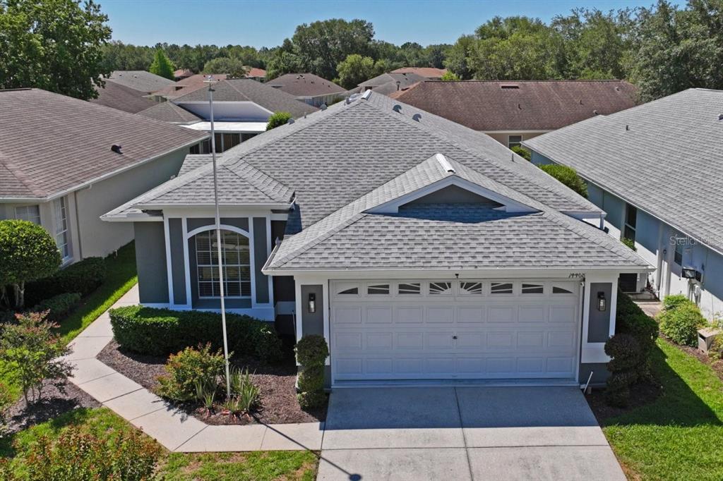 An aerial view shows the front exterior of a single-story house with a gray roof — 14468 MIDDLE FAIRWAY DRIVE, SPRING HILL, FL