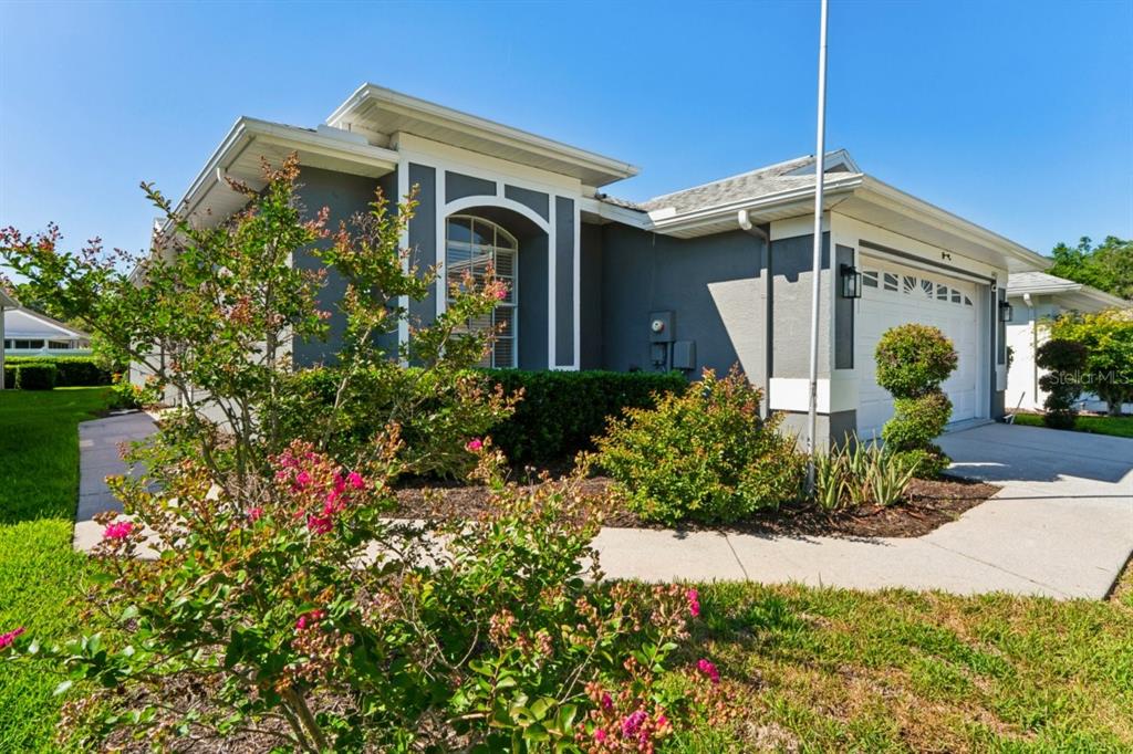 A gray single-story house with a white-trimmed arched window and a two-car garage — 14468 MIDDLE FAIRWAY DRIVE, SPRING HILL, FL