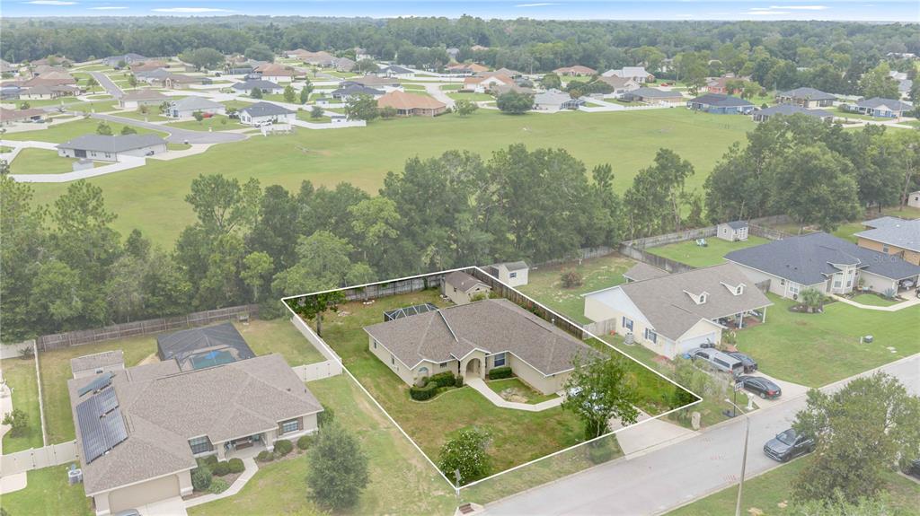 An aerial view shows a single-story suburban house with a fenced backyard and driveway — 1363 SE 65TH CIRCLE, OCALA, FL