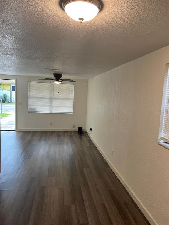 An empty room features wood-look flooring, a ceiling fan, and a window with blinds — 10702 N 14TH STREET UNIT 2, TAMPA, FL