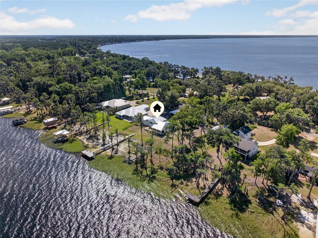An aerial view shows a waterfront house surrounded by trees and a private dock — 2473 SE 30TH STREET, MELROSE, FL