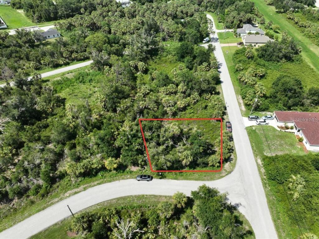 An aerial view shows a vacant, wooded lot outlined in red along a paved road — JINRIGHT ROAD, NORTH PORT, FL