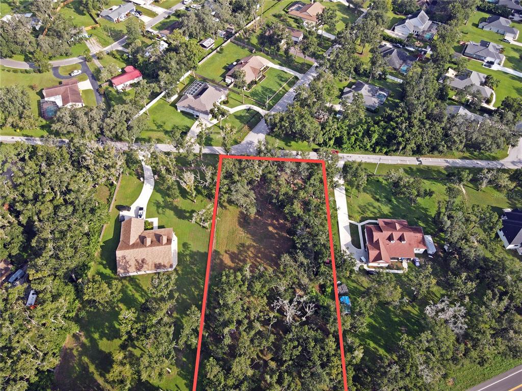 An aerial view shows a rectangular vacant lot outlined in red between two residential houses — 35174 ROTH LANE, DADE CITY, FL
