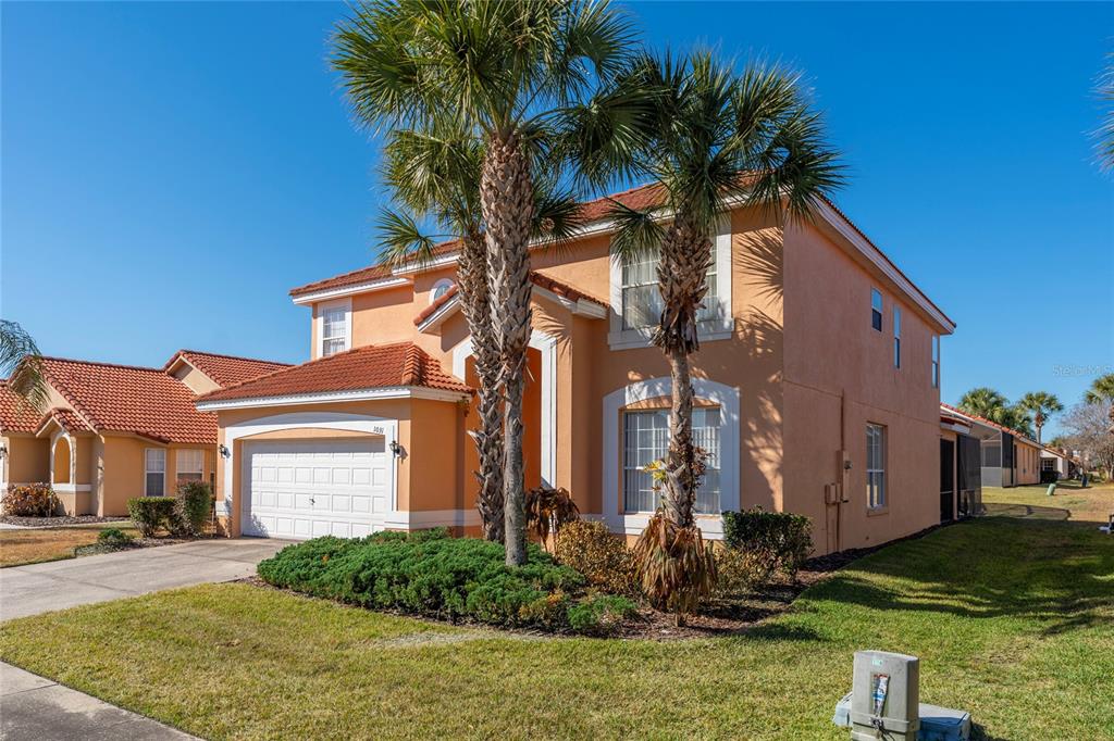 A two-story, orange-stucco house with a tile roof and two palm trees in the front — 1031 SOLANA CIRCLE, DAVENPORT, FL