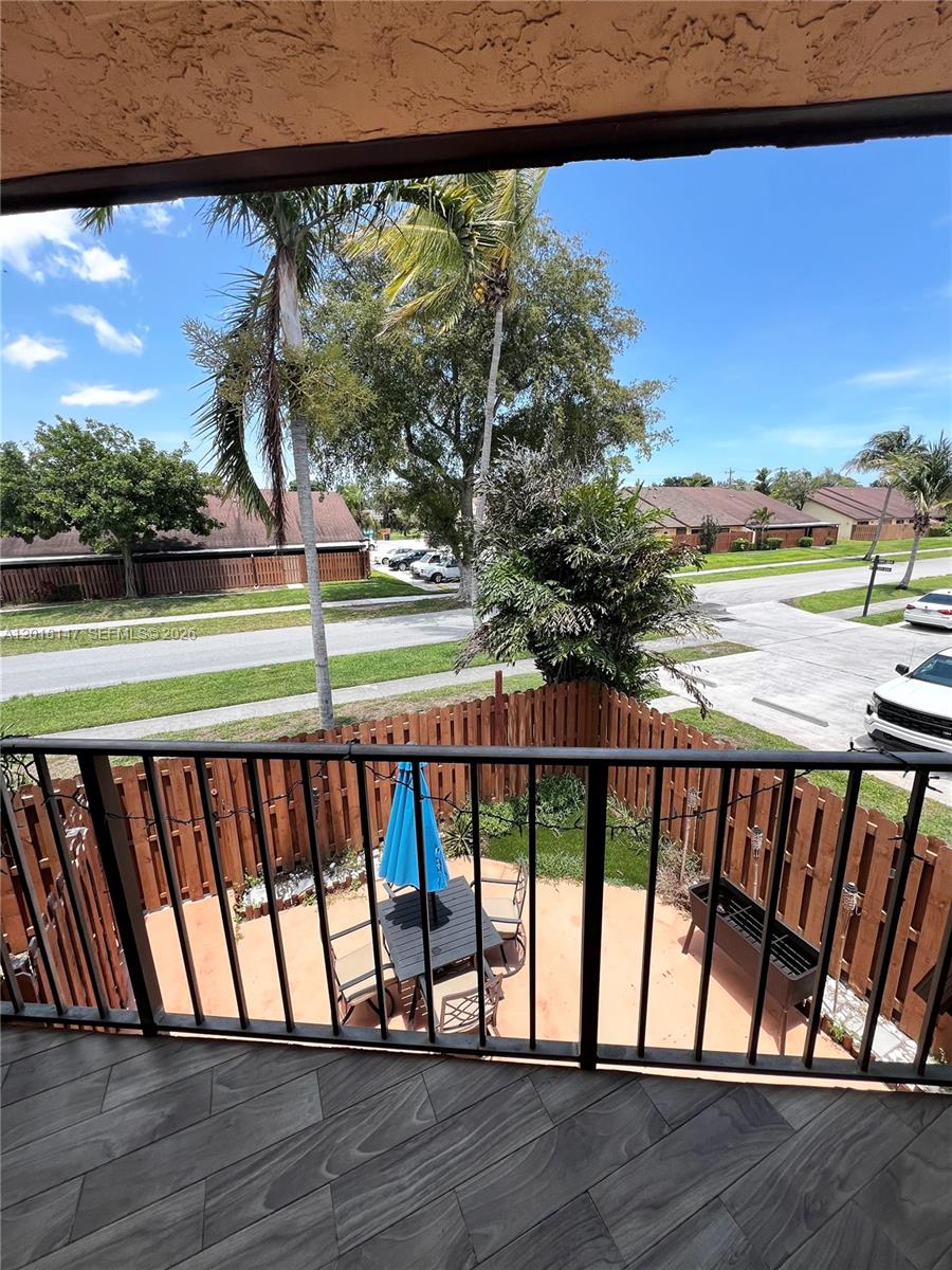 A view from a balcony overlooking a fenced patio, a street, and residential buildings — 192 Springdale Cir # 192, Palm Springs FL 33461, PALM SPRINGS, FL