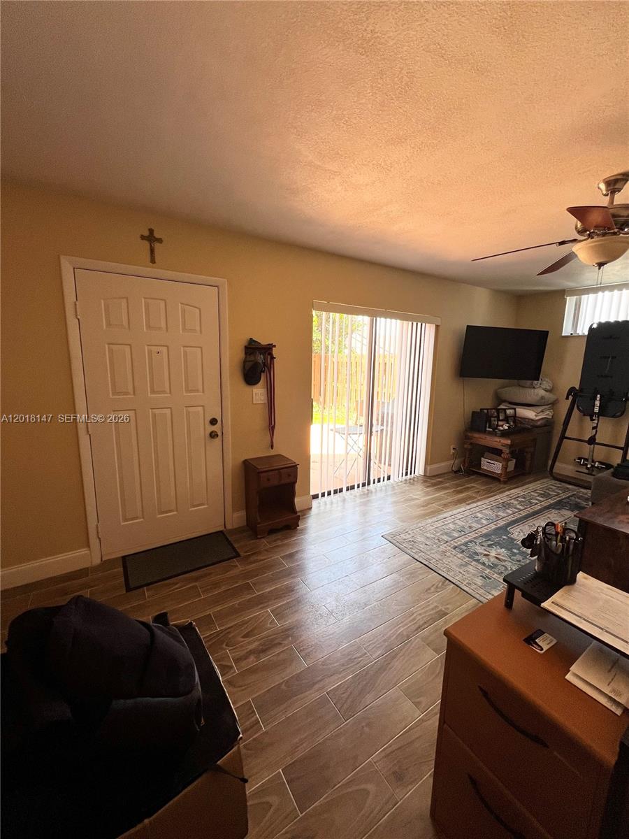 A living room features tile flooring, a sliding glass door, and a ceiling fan — 192 Springdale Cir # 192, Palm Springs FL 33461, PALM SPRINGS, FL