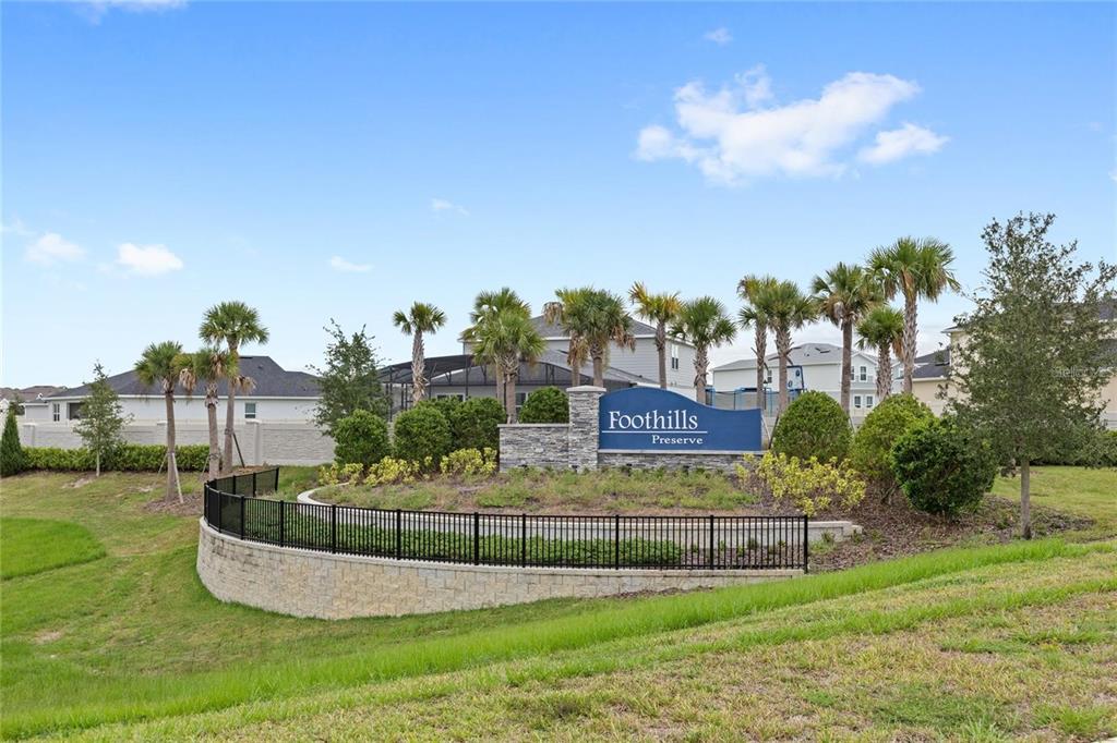 A stone monument sign for Foothills Preserve sits behind a black fence and landscaping — 5936 STONEYBROOK HILLS PARKWAY, MOUNT DORA, FL