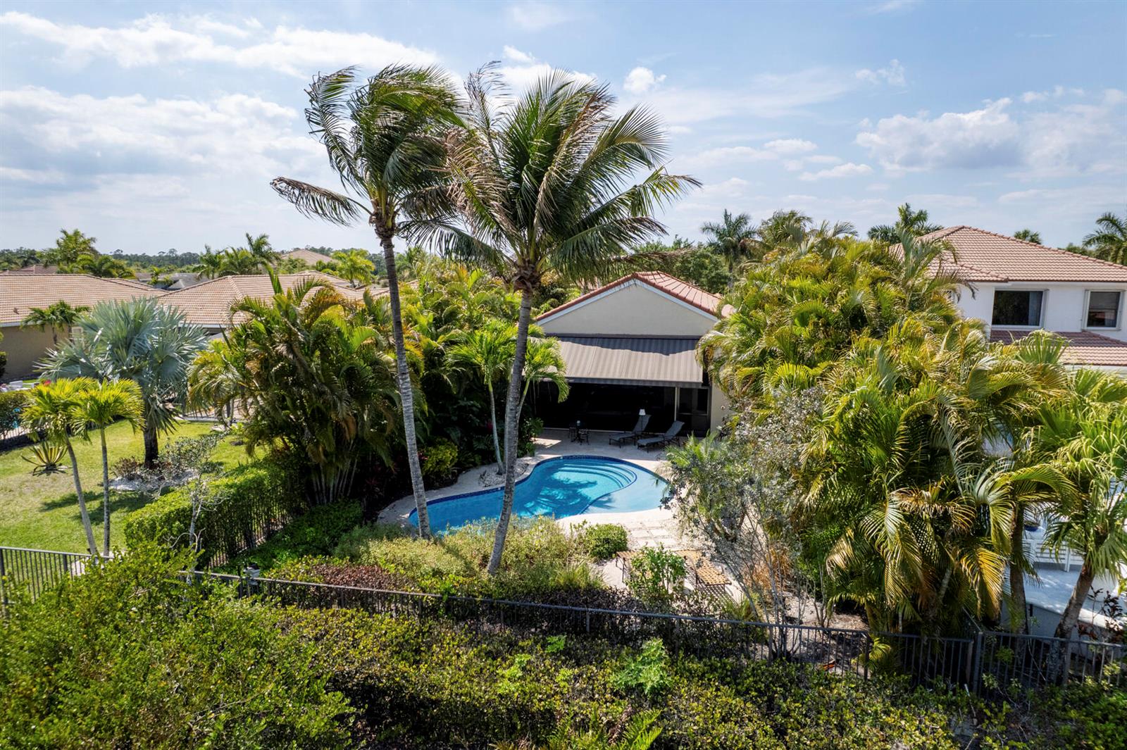 An aerial view shows a backyard with a swimming pool, palm trees, and a house — 6700 Fox Hollow Drive, West Palm Beach FL 33412, WEST PALM BEACH, FL