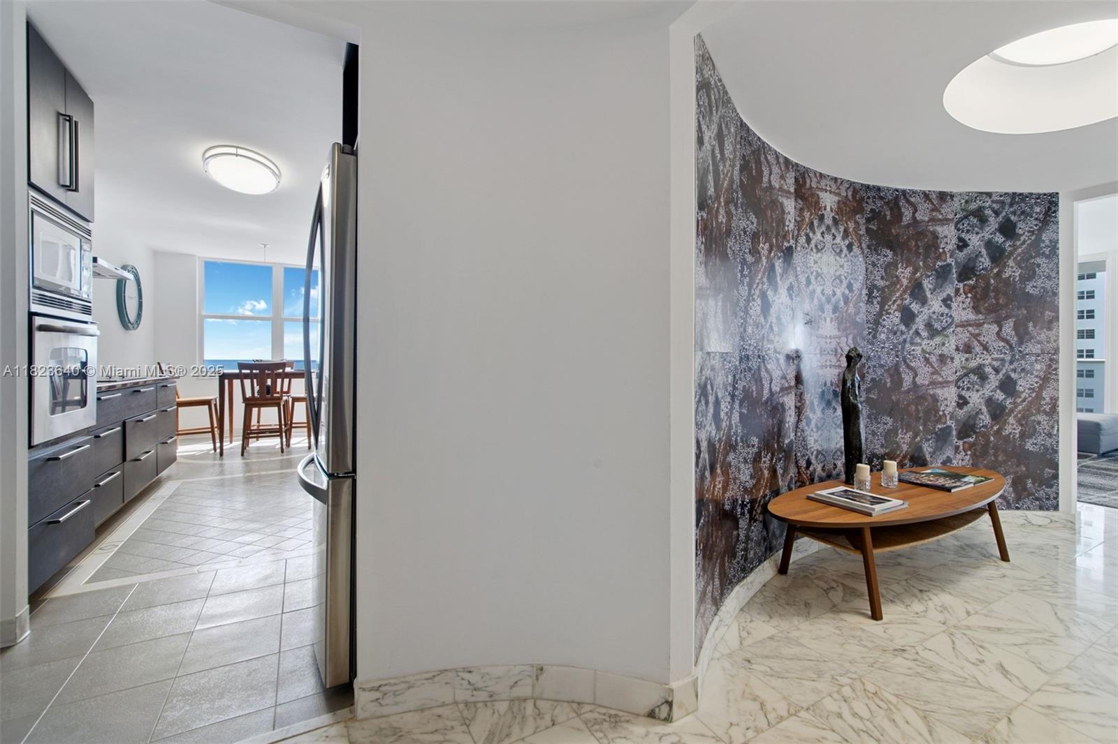 A kitchen with dark cabinets and a curved wall featuring decorative stone-look paneling — 2751 S Ocean Dr # 505N, Hollywood FL 33019, HOLLYWOOD, FL