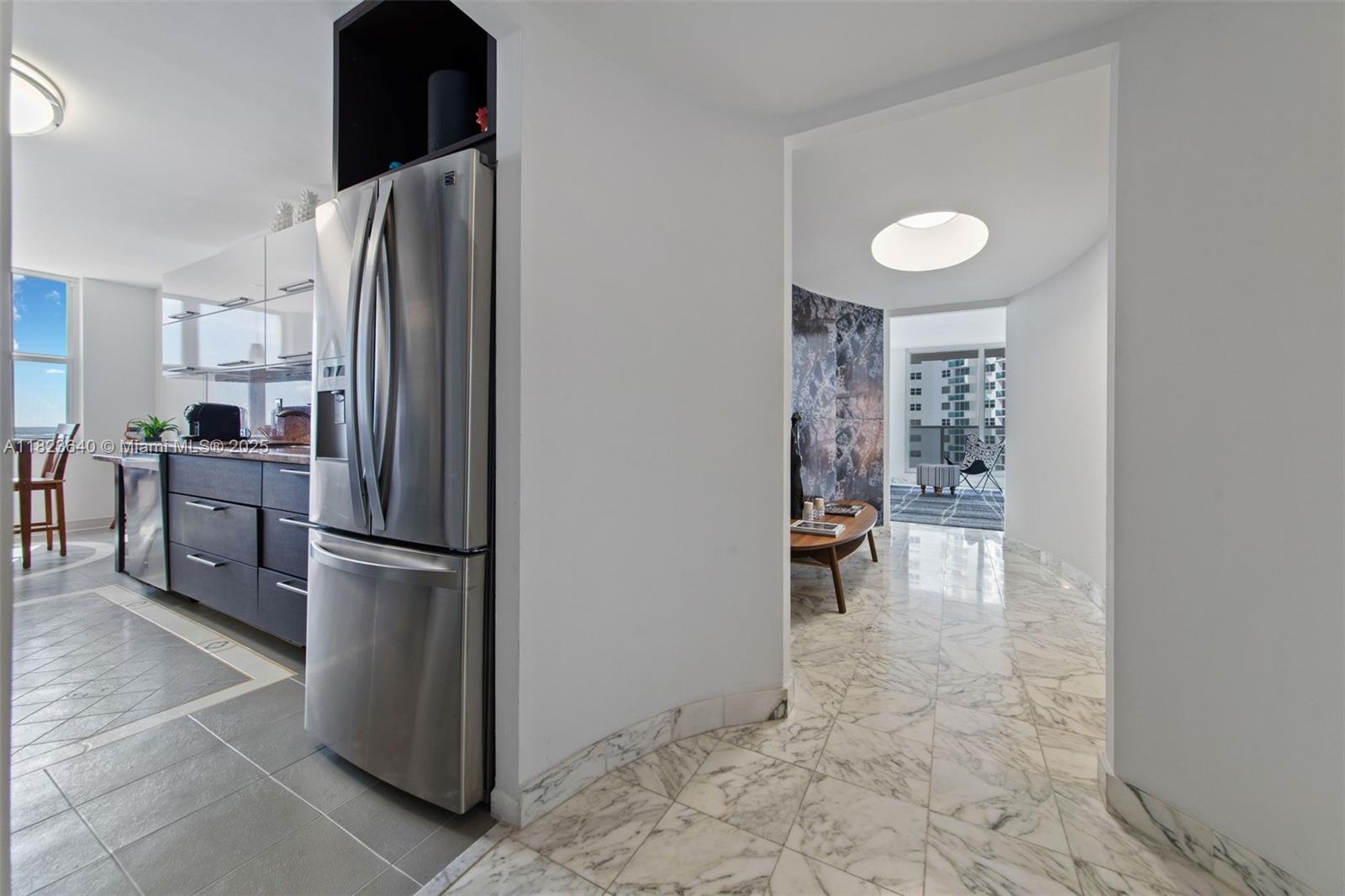 A stainless steel refrigerator stands in a kitchen next to a marble-floored hallway — 2751 S Ocean Dr # 505N, Hollywood FL 33019, HOLLYWOOD, FL