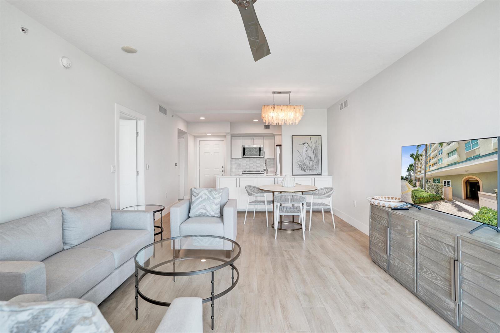 A living room and dining area with light wood floors, a sofa, and a kitchen — 700 E Boynton Beach Boulevard # 406, Boynton Beach FL 33435, BOYNTON BEACH, FL