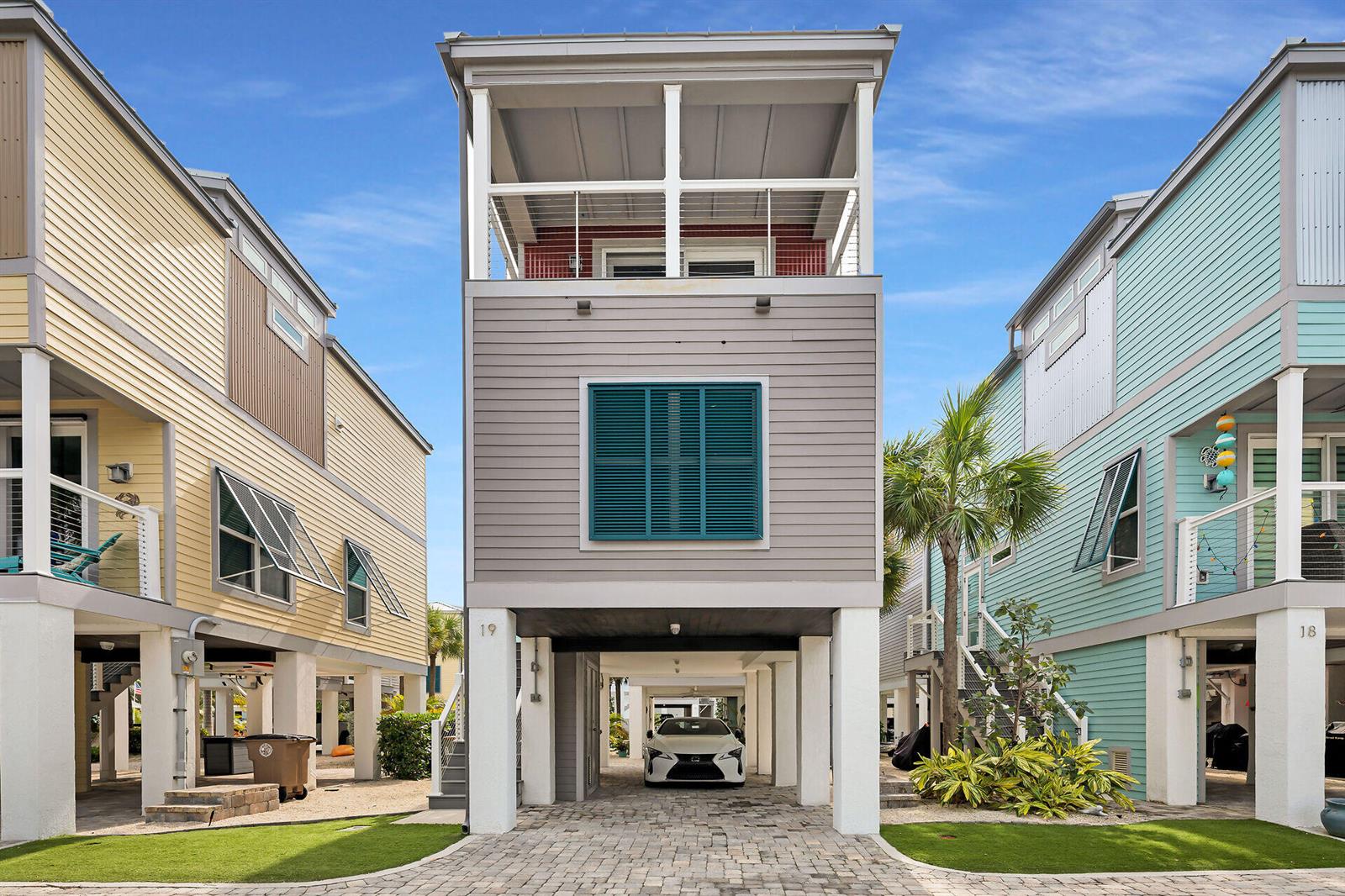 A three-story house on stilts with a paved driveway and a parked white car — 101 11th Street # 19, Marathon FL 33050, MARATHON, FL