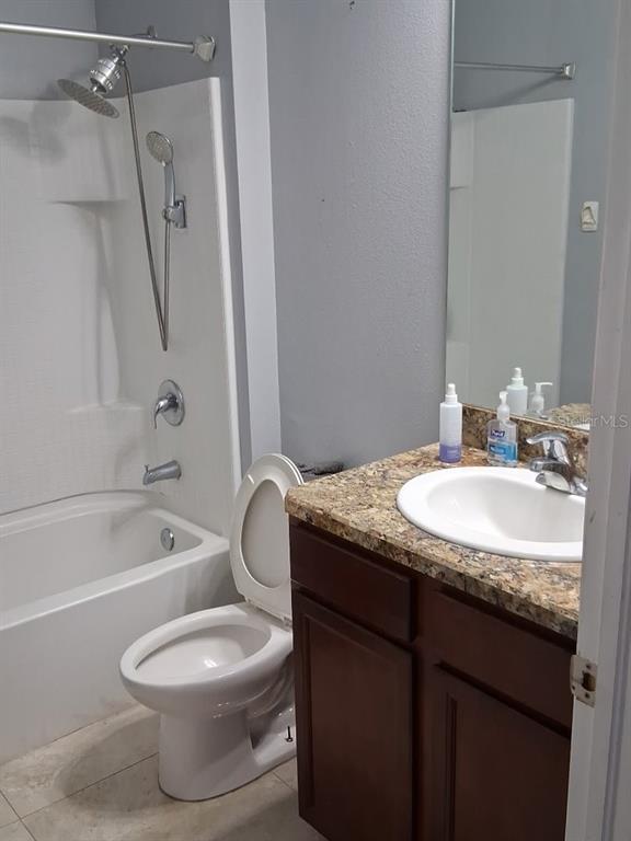 A bathroom features a white tub-shower combo, a toilet, and a dark wood vanity — 405 BLAKELY COURT, RUSKIN, FL