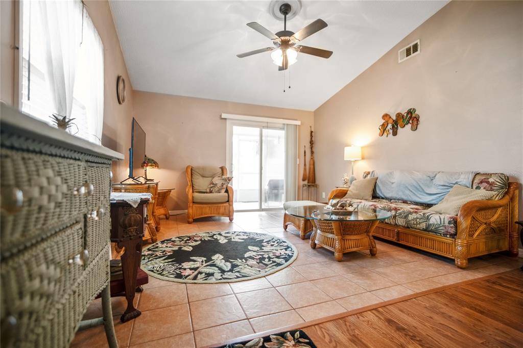 A living room features tile flooring, a wicker sofa set, and a ceiling fan — 2835 NORDMAN AVENUE, NEW SMYRNA BEACH, FL