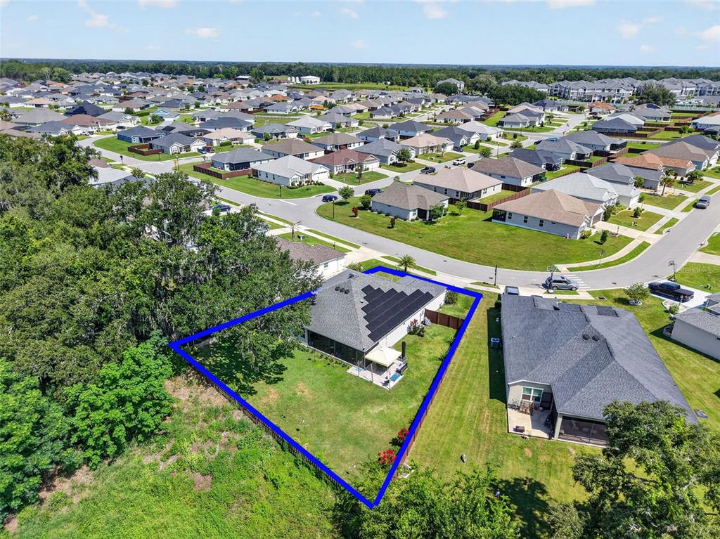 A single-story house with a two-car garage, gray siding, and a landscaped front yard — 11387 ZIMMERMAN PATH, OXFORD, FL