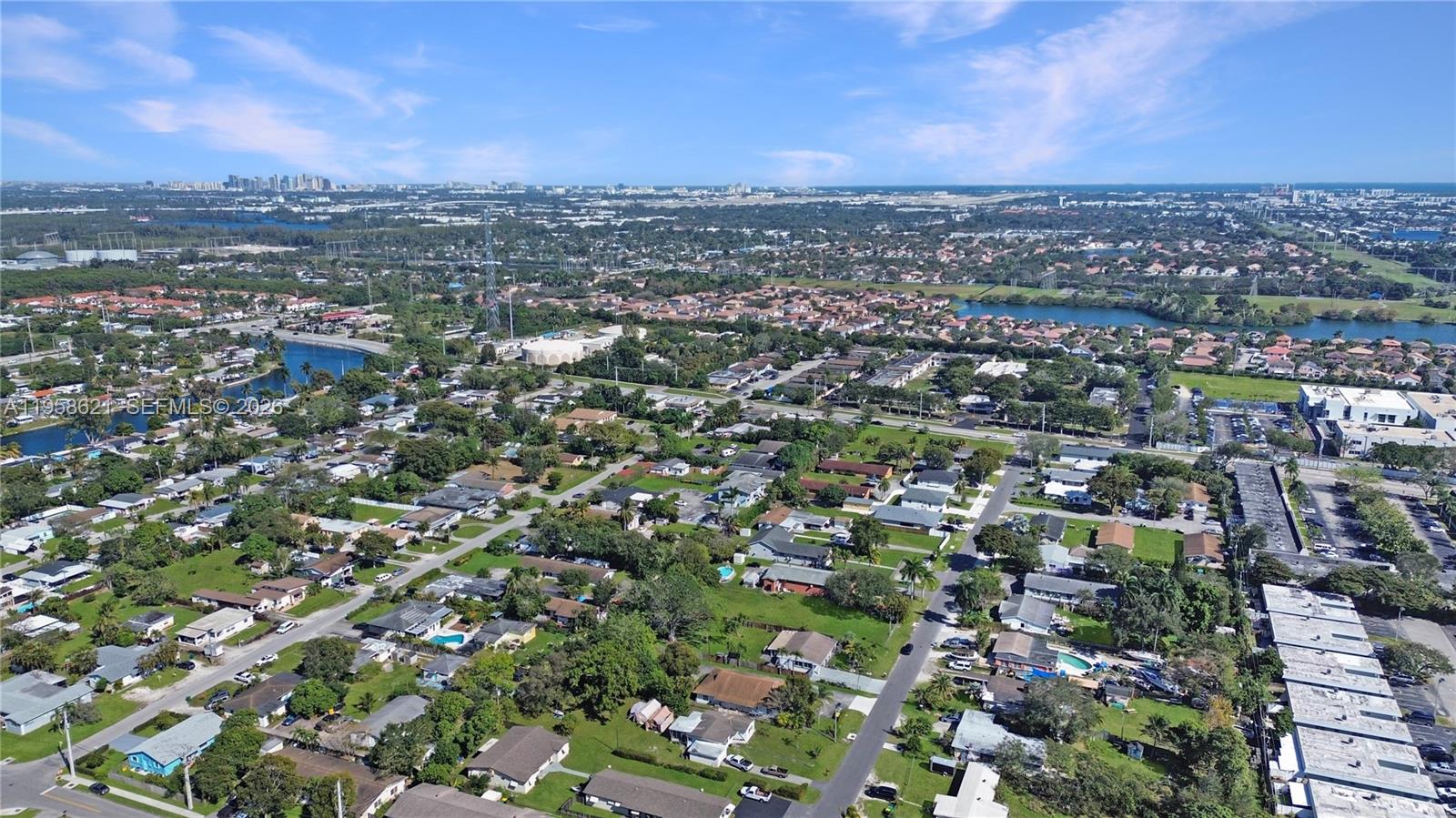 An aerial view shows a residential neighborhood with houses, swimming pools, and nearby commercial buildings — 4133 SW 52nd St, Dania Beach FL 33314, DANIA BEACH, FL