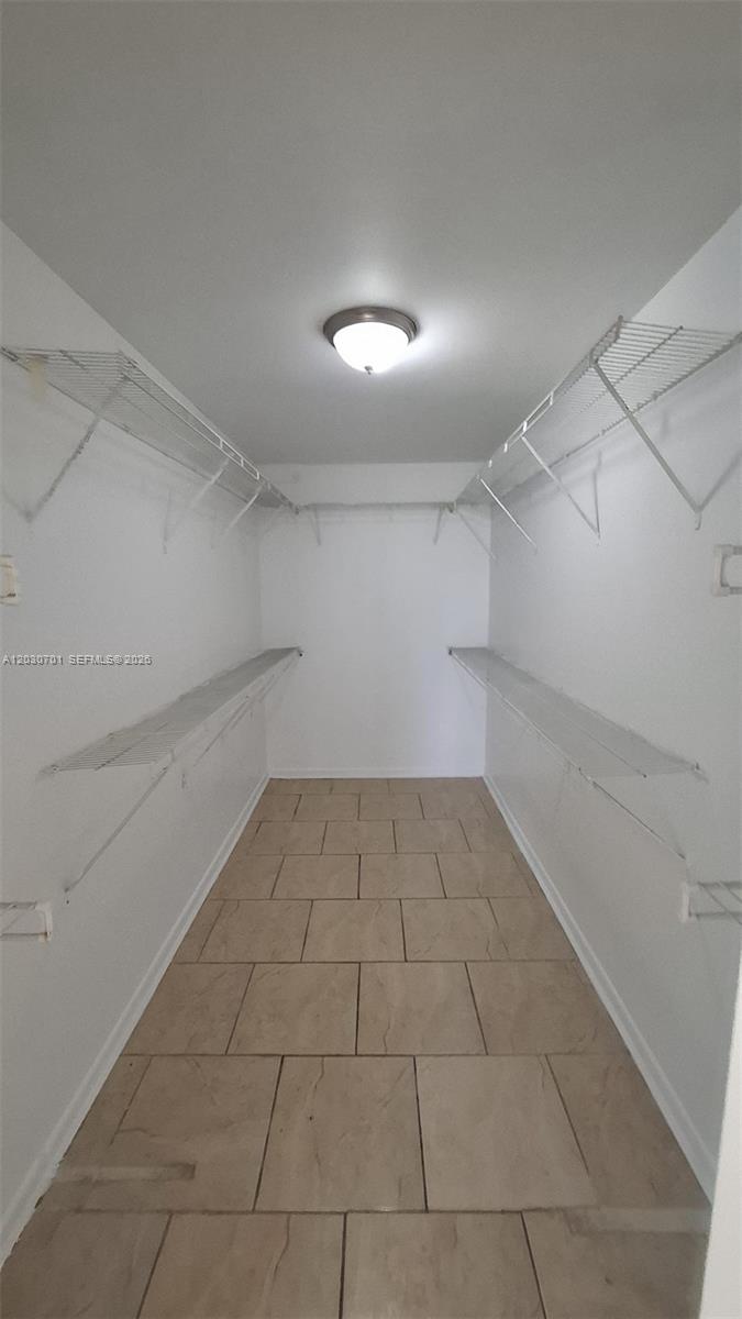 A kitchen features white cabinets, granite countertops, a stainless steel sink, and a drop ceiling — 6950 Miami Gardens Dr # 304, Hialeah FL 33015, HIALEAH, FL