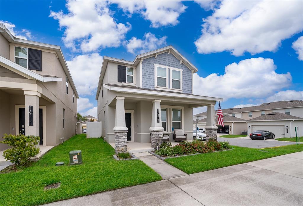 A two-story house with a covered front porch, stone columns, and blue siding — 16105 WATER SPRING BOULEVARD, WINTER GARDEN, FL