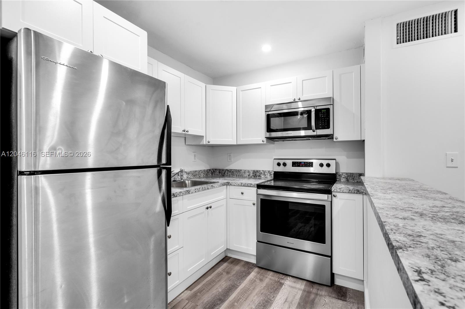 A kitchen features white cabinets, stainless steel appliances, and gray-patterned countertops — 6445 NW 2nd Ave # 19, Miami FL 33150, MIAMI, FL