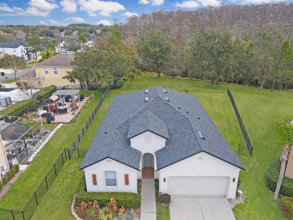 An aerial view shows a single-story house with a dark shingled roof and garage — 13313 HALKYN POINT, ORLANDO, FL