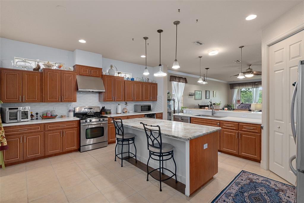 A kitchen with wood cabinets, granite countertops, a center island, and stainless steel appliances — 5248 ESPLANDE COURT, BROOKSVILLE, FL
