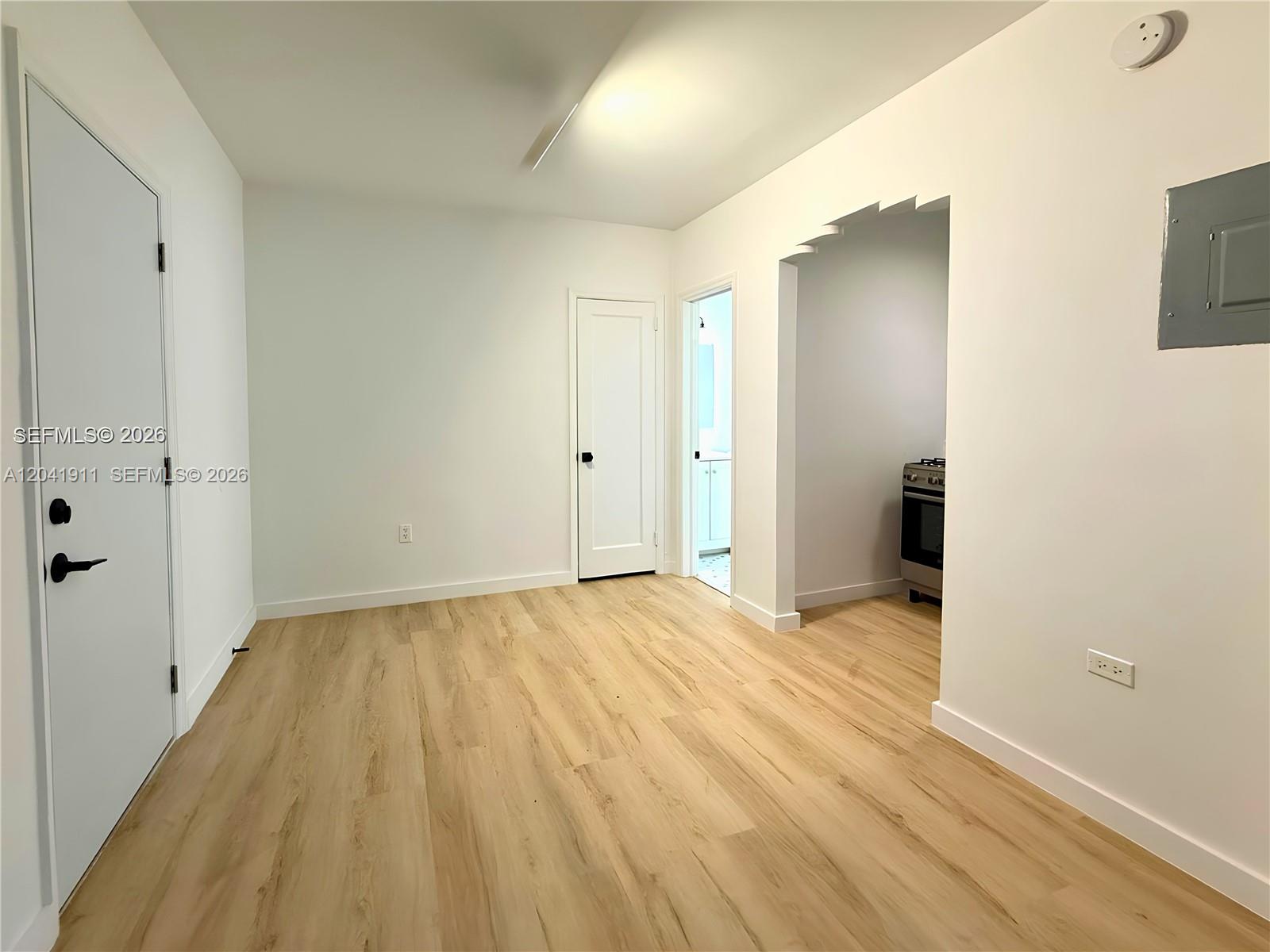 An interior view shows a room with light wood flooring, white walls, and two doorways — 641 10th St # 2, Miami Beach FL 33139, MIAMI BEACH, FL