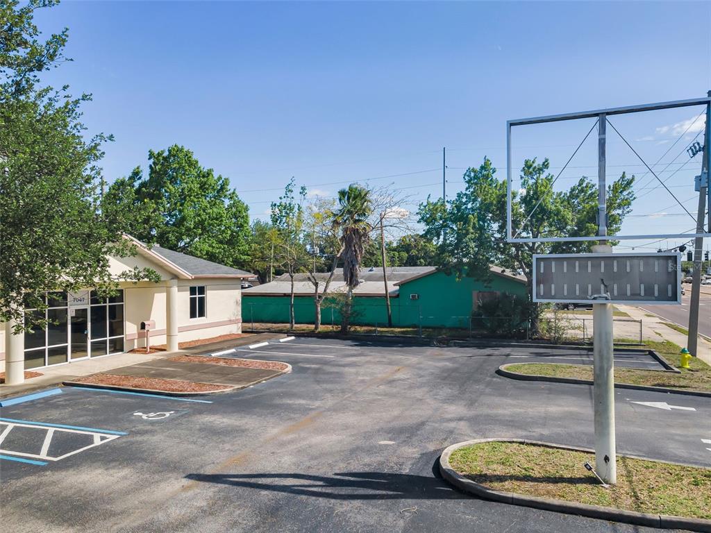 A commercial building with a parking lot and a large billboard structure — 7047 66TH STREET N, PINELLAS PARK, FL