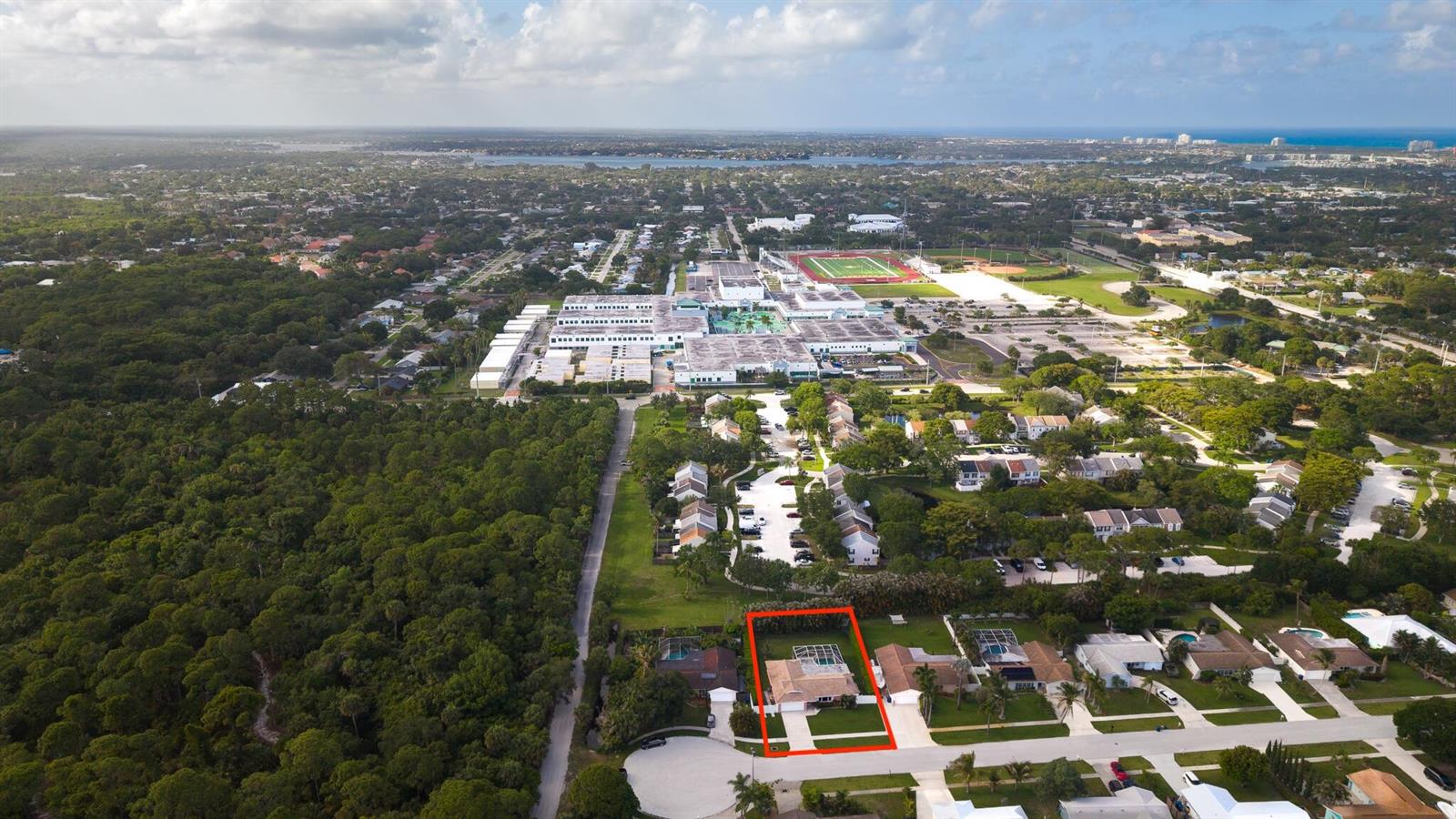 An aerial view shows a residential property highlighted in red within a suburban neighborhood — 613 Oak Terrace, Jupiter FL 33458, JUPITER, FL