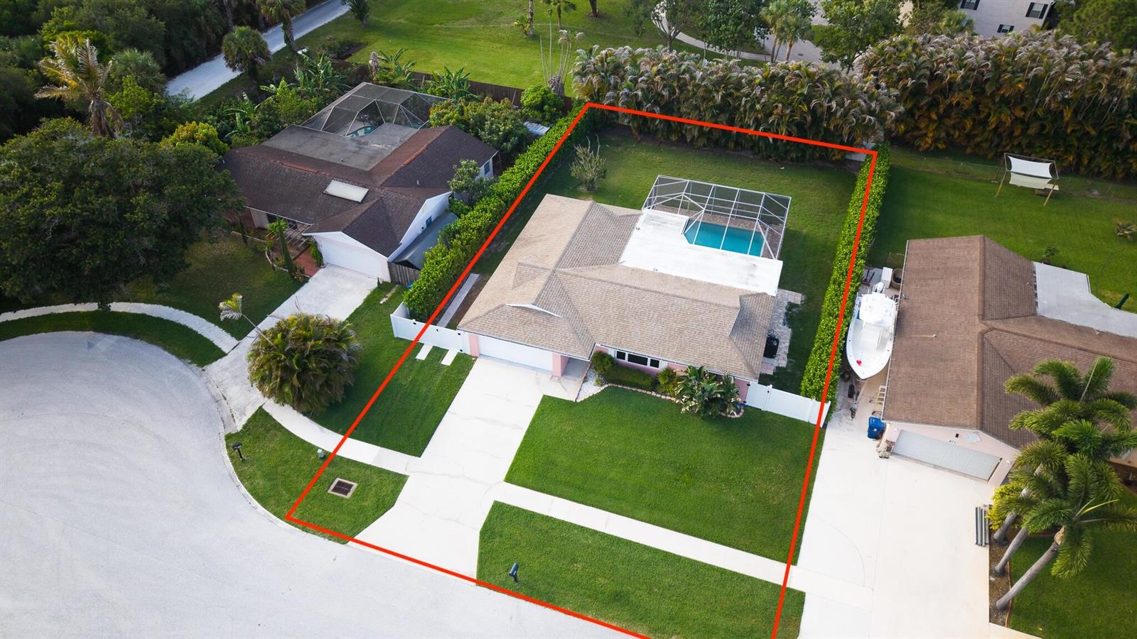 An aerial view shows a single-story house with a pool enclosure and a fenced yard — 613 Oak Terrace, Jupiter FL 33458, JUPITER, FL