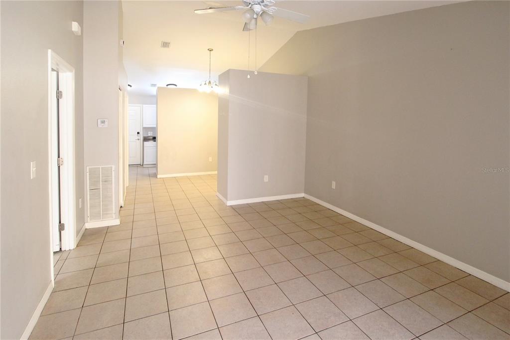 An open-concept living area features light-colored tile flooring, gray walls, and a ceiling fan — 864 HAND AVE, SARASOTA, FL