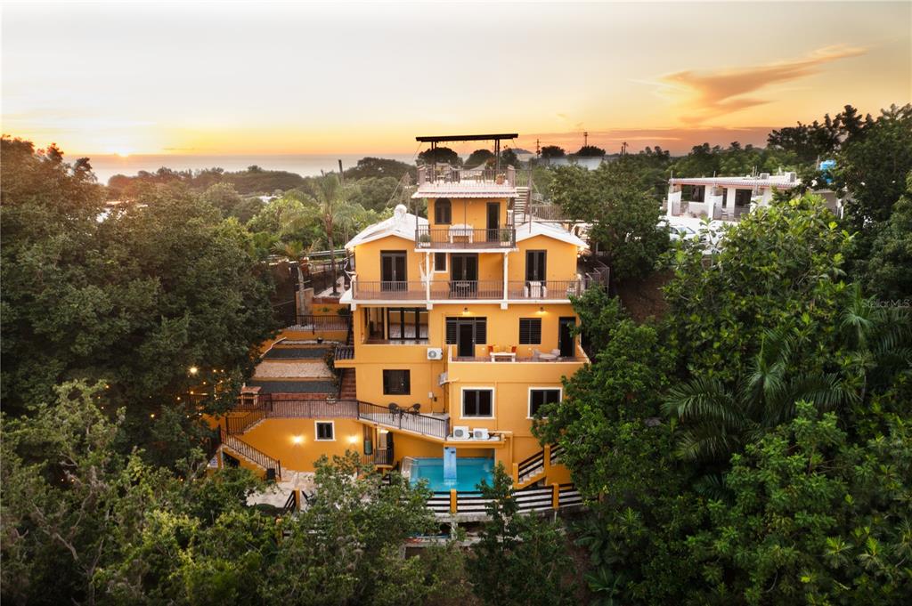 An aerial view of a multi-story yellow house with a pool and rooftop deck — CARR. 414 KM 1.8 INT THE TERRACES, RINCON, PR