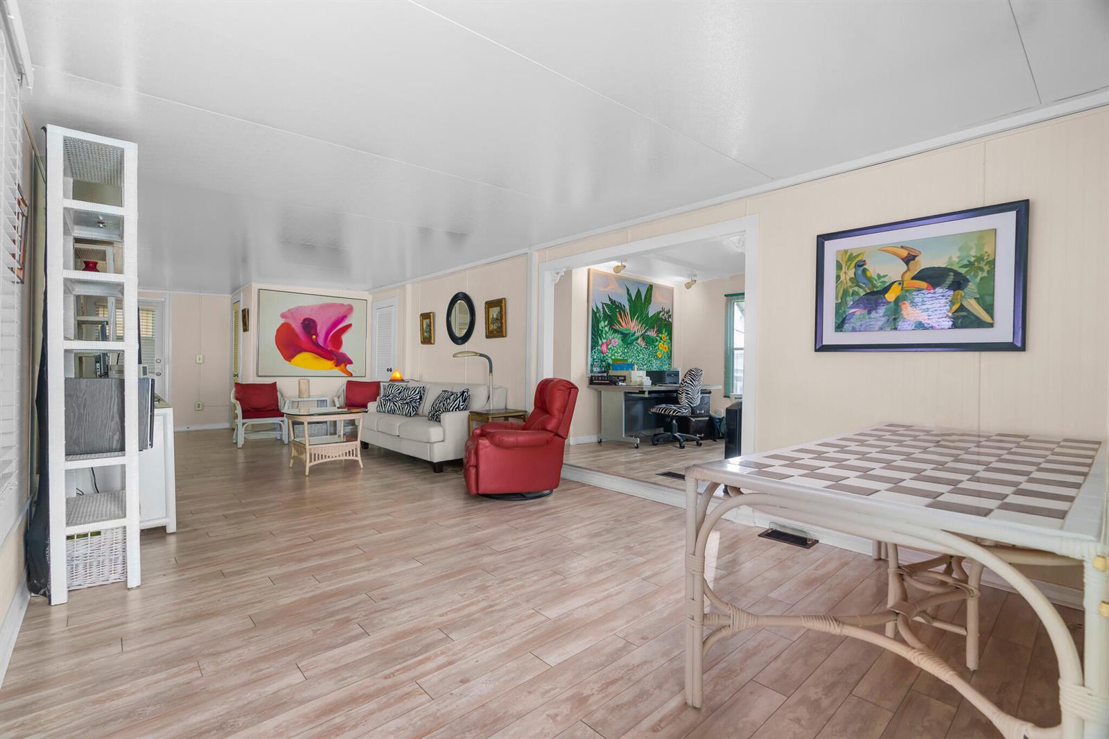 A living room with light wood-look flooring, a red recliner, and a dining table — 202 N Ibis, Briny Breezes FL 33435, BRINY BREEZES, FL