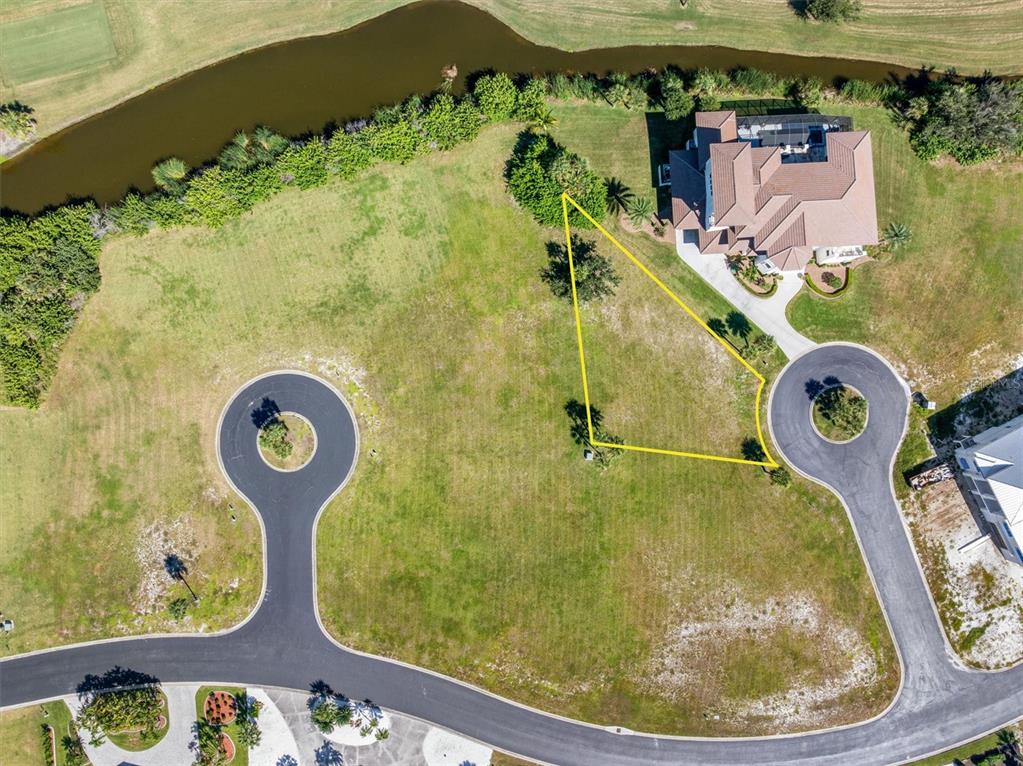 An aerial view shows a vacant residential lot outlined in yellow next to a house — 9310 TALON COURT, ENGLEWOOD, FL