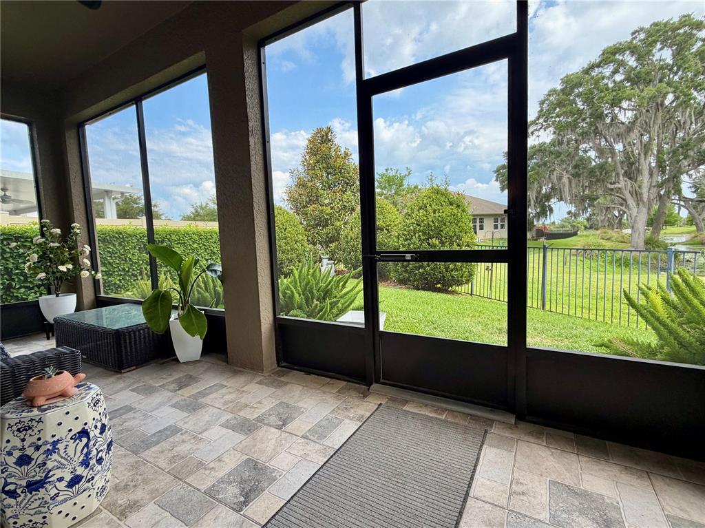 A living room features tile flooring, a large sectional sofa, and a dark wood media center — 15665 CITRUS HARVEST ROAD, WINTER GARDEN, FL