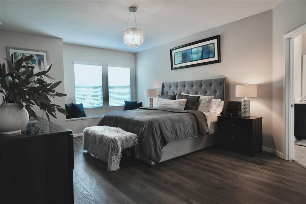 A dining room features a dark table, white-backed chairs, tile flooring, and a chandelier — 15665 CITRUS HARVEST ROAD, WINTER GARDEN, FL