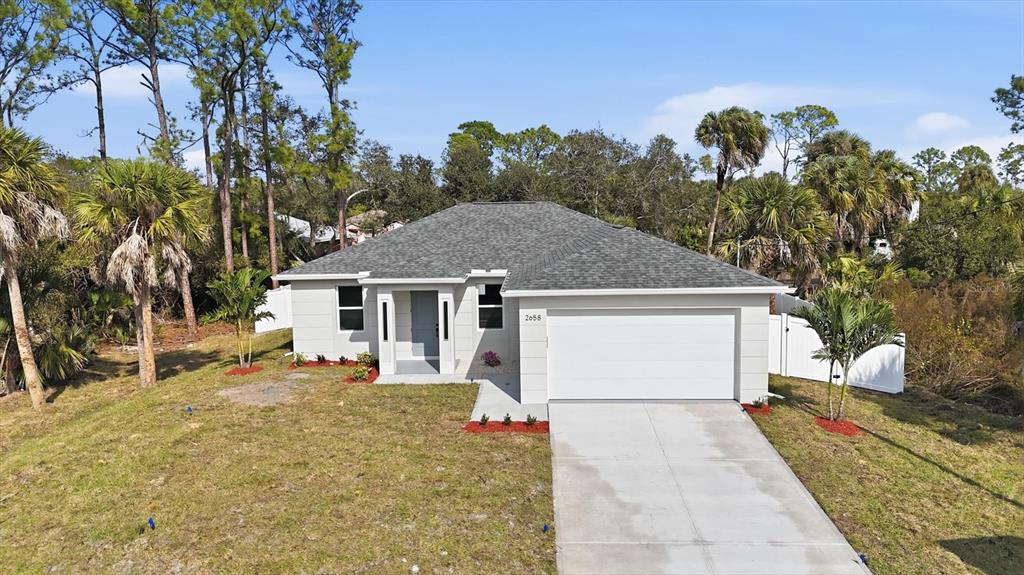 A single-story house with a gray shingled roof, white exterior, and a two-car garage — 2658 ALLSUP TERRACE, NORTH PORT, FL