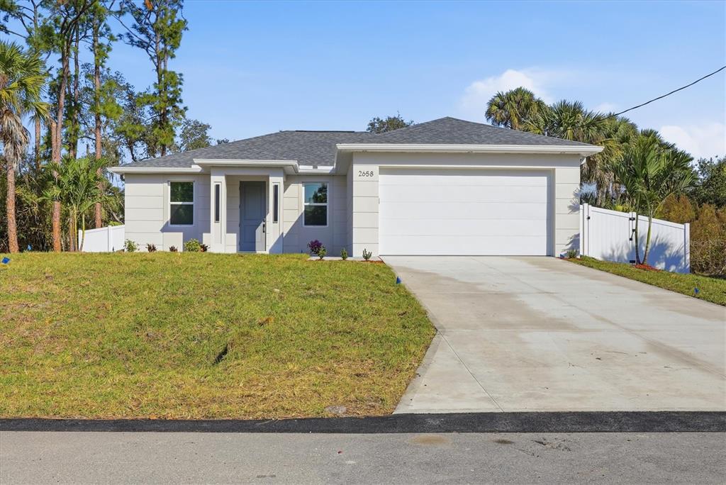 A single-story house with a white exterior, a concrete driveway, and a two-car garage — 2658 ALLSUP TERRACE, NORTH PORT, FL