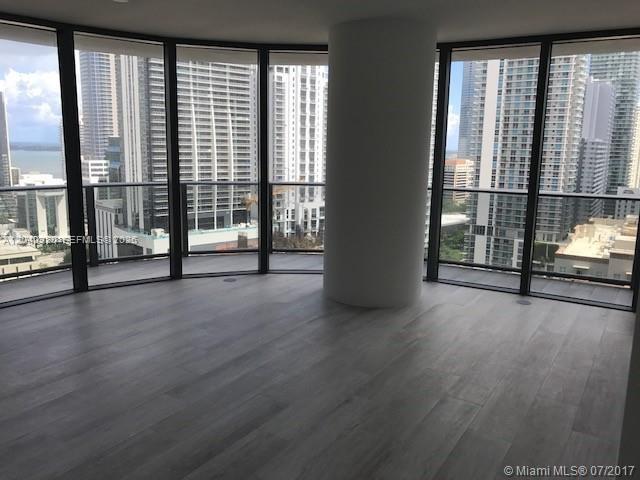 An empty room with floor-to-ceiling windows, a central structural column, and light wood flooring — 55 SW 9th St # 2103, Miami FL 33130, MIAMI, FL