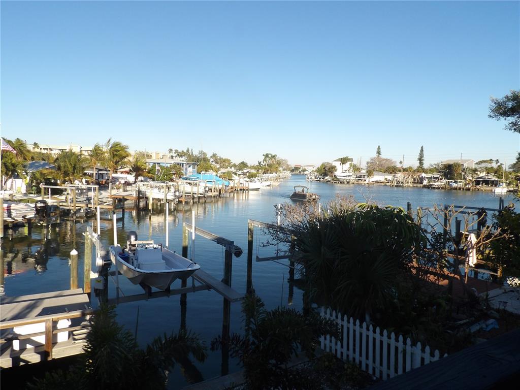 A view of a canal with boat docks, moored vessels, and surrounding residential homes — 14975 1ST STREET E, MADEIRA BEACH, FL