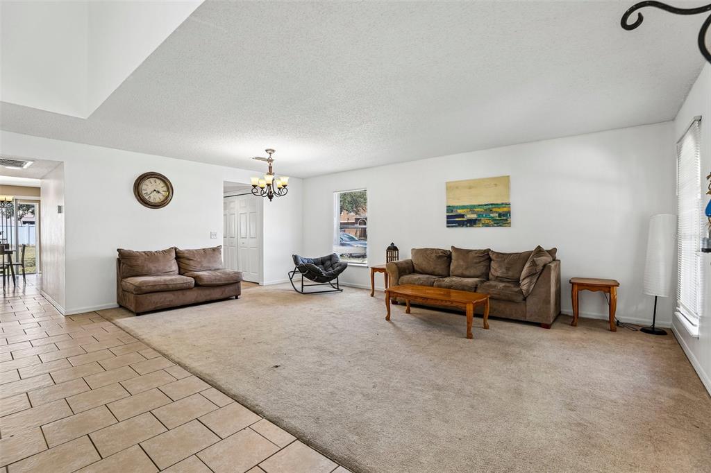 A living room features beige carpeting, white walls, a brown sofa, and a tile entryway — 274 JOCELYN DRIVE, DAVENPORT, FL