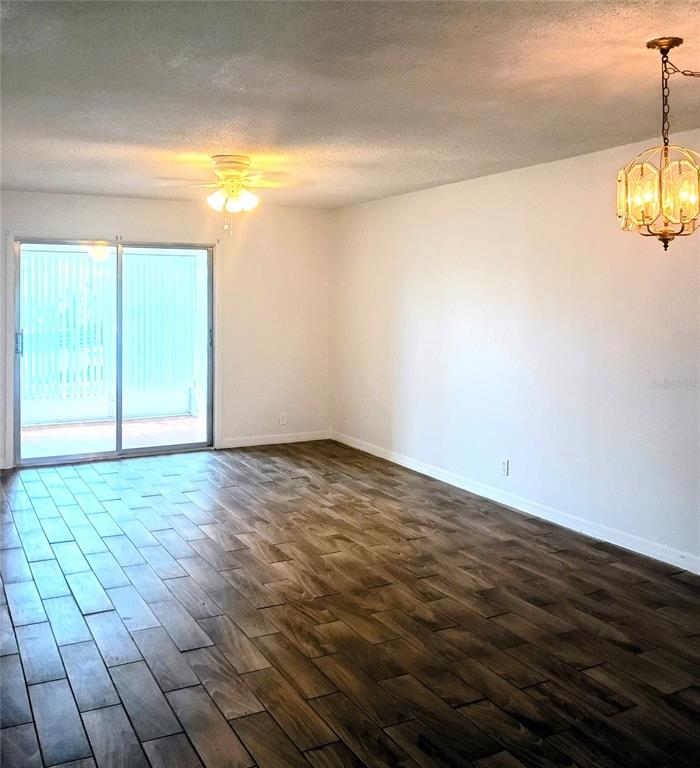 A room with wood-look tile flooring, a ceiling fan, and a sliding glass door — 333 LAKE HOWARD DRIVE NW UNIT 312C, WINTER HAVEN, FL
