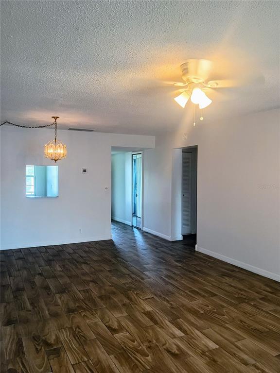 A room with wood-look tile flooring, a ceiling fan, and a hanging pendant light fixture — 333 LAKE HOWARD DRIVE NW UNIT 312C, WINTER HAVEN, FL