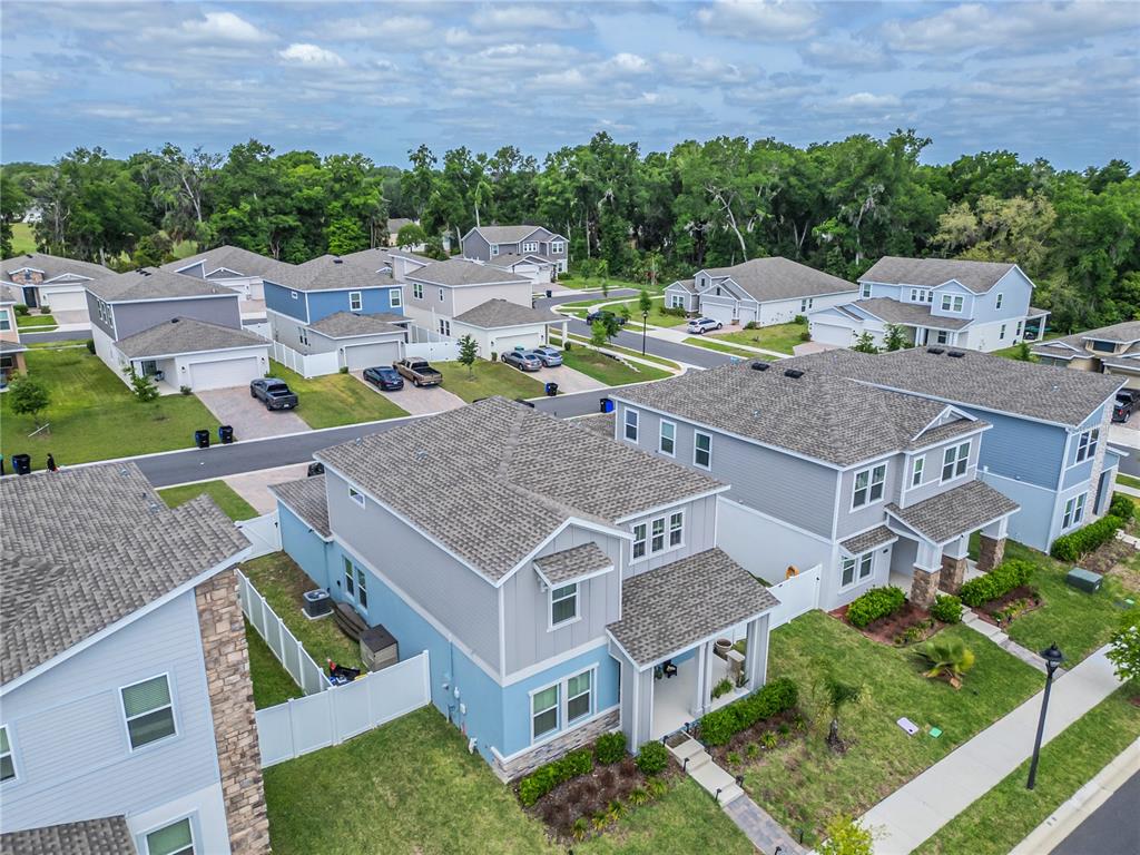 An aerial view shows several two-story suburban houses with gray roofs and light-colored siding — 2200 SWEET HONEY LANE, APOPKA, FL