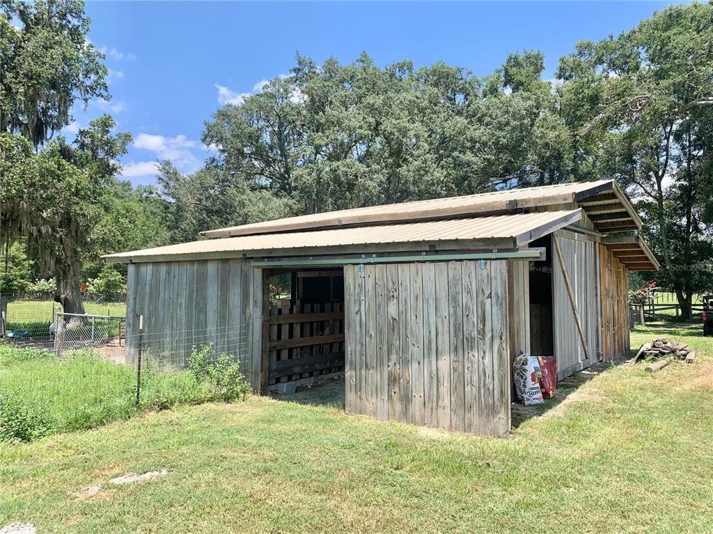 A weathered wooden barn with a metal roof stands in a grassy field — 15770 NW 60TH AVENUE, CHIEFLAND, FL
