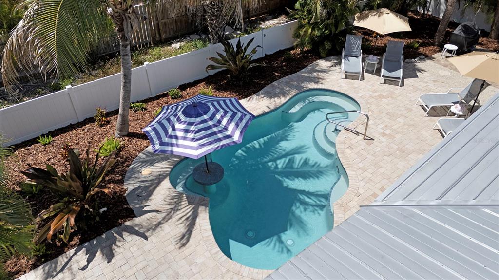 An aerial view shows a backyard swimming pool with a built-in table and umbrella — 110 PALM AVENUE, ANNA MARIA, FL
